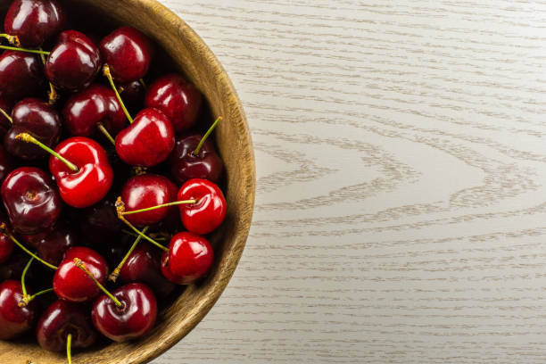 istock Fresh raw sweet red cherry on grey wood 996487010