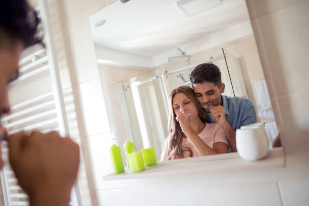 istock Young couple brushing teeth together at home 996495474