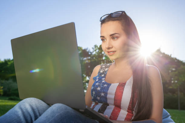 pretty young woman sitting on bean bag use laptop while resting on grass in park on the sun - coffee bean bag human hand imagens e fotografias de stock