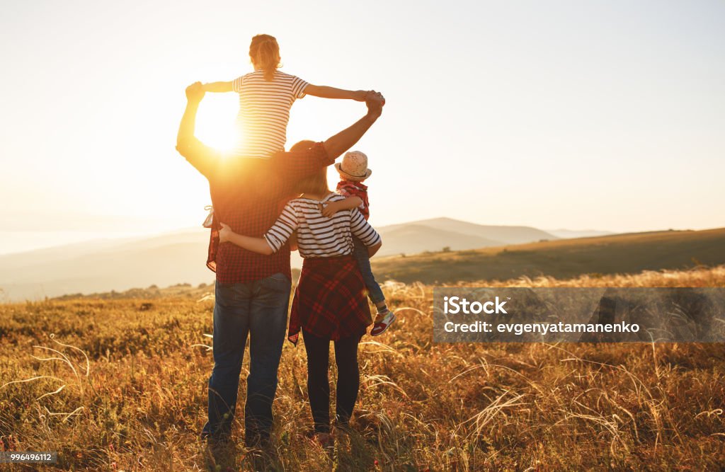 Familia feliz: madre, padre, hijos hijo e hija en puesta de sol - Foto de stock de Familia libre de derechos