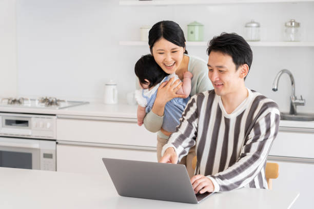 młoda azjatycka rodzina używająca laptopa w kuchni - two parent family asian ethnicity couple computer zdjęcia i obrazy z banku zdjęć