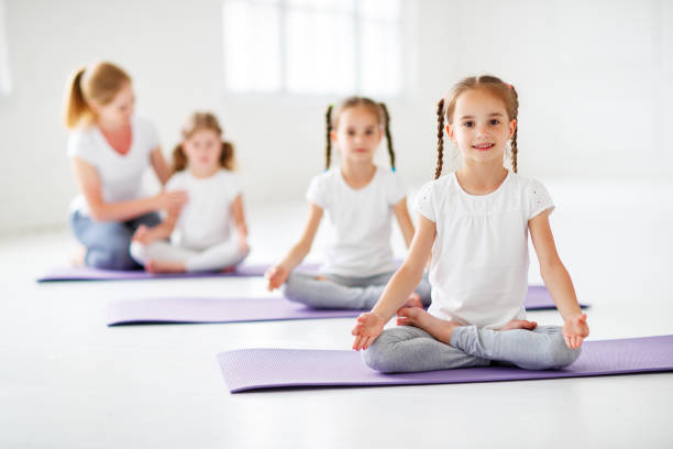 istock children practicing engaged in gymnastics and yoga with  teacher 996504902