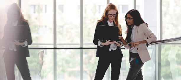 istock Business people talking in office lobby with glass wall 996507802