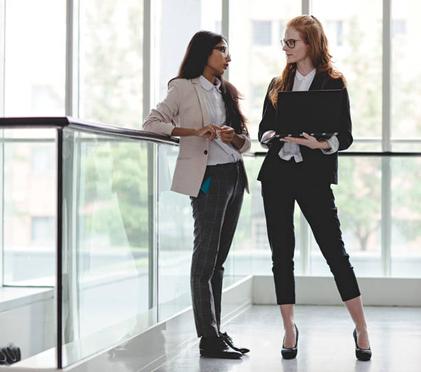 istock Business people talking in office lobby with glass wall 996507838