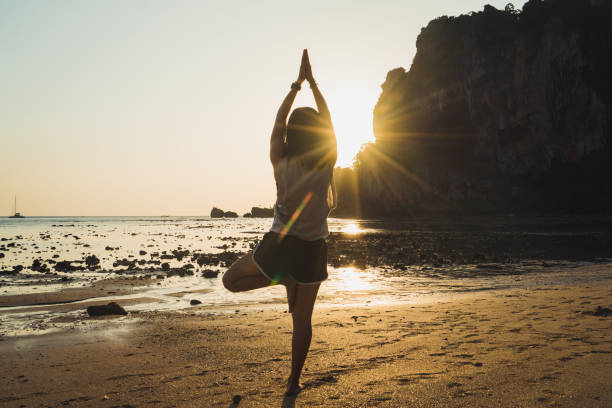 istock Woman balancing in yoga pose on beach 996510830