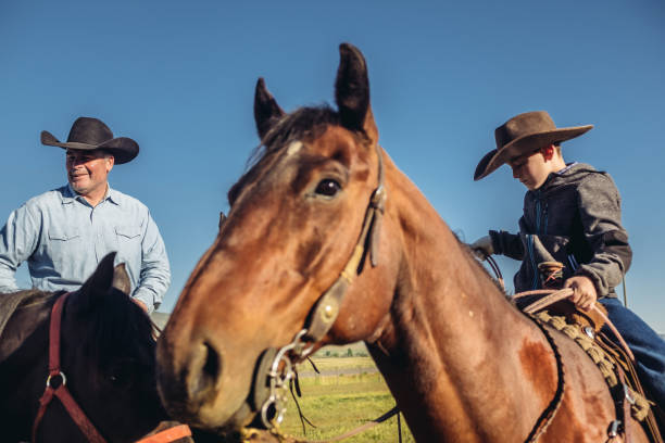 istock Utah cowboy and his son riding 996527154