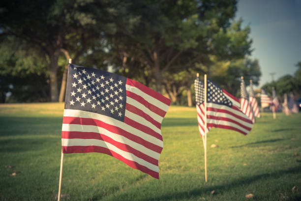 istock Vintage American Flags on green grass lawn Independence Day 996548500