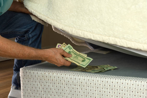 istock Man hiding money under his mattress because he doesn't trust banks 996555804