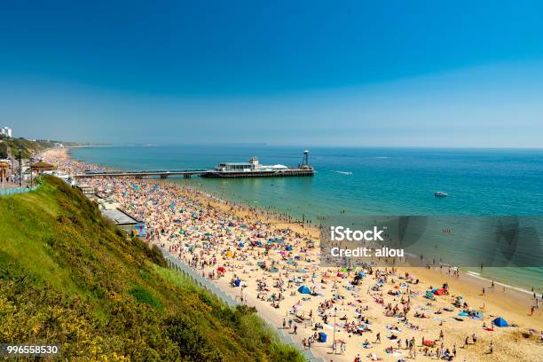 Sunbathers Pack Bournemouth Beach Near The Pier Stock Photo - Download Image Now - Bournemouth - England, Beach, UK