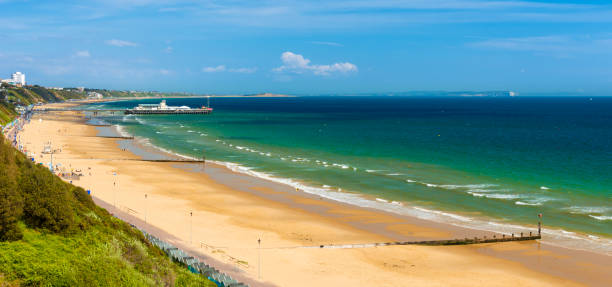 Sunshine illuminates golden beaches and blue-green seas along the Dorset coast between Poole and Bournemouth
