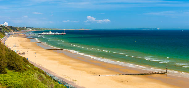 Bournemouth beach, pier, sea and sand Sunshine illuminates golden beaches and blue-green seas along the Dorset coast between Poole and Bournemouth sandbanks poole harbour stock pictures, royalty-free photos & images