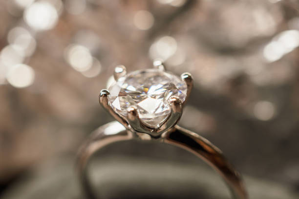 istock luxury engagement Diamond ring with abstract bokeh light background 996576036