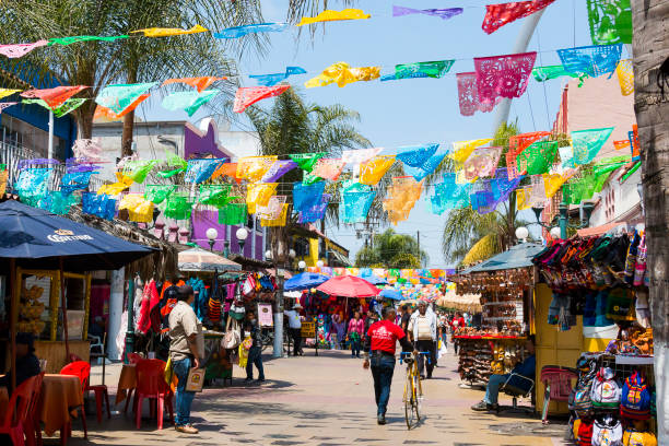 People Shop Beneath Hanging Flags in Tijuana, Mexico stock photo