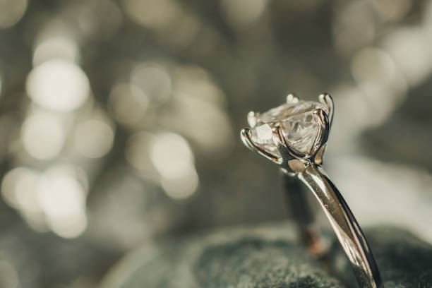 istock luxury engagement Diamond ring in jewelry gift box with bokeh light background 996576074