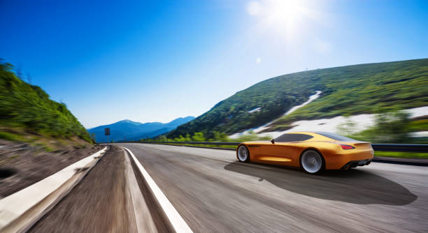 istock orange car driving on a mountain road 996576448