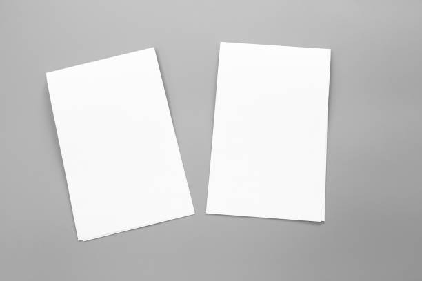 istock Blank portrait A4. brochure magazine isolated on gray, changeable background / white paper business card isolated on gray 996579510