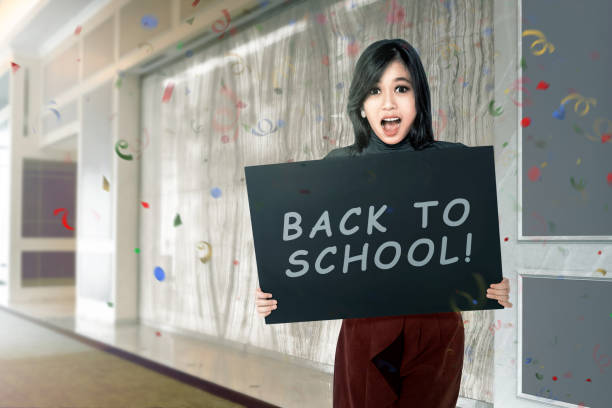 istock Happy asian student woman with board with back to school text 996579724