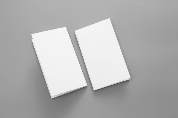 istock Blank portrait A4. brochure magazine isolated on gray, changeable background / white paper business card isolated on gray 996579828
