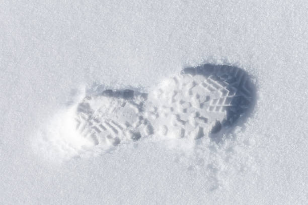 istock Foot imprint in white snow, close-up 996585730
