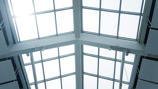 View through modern skylight of blue glass. Roof of building. Contemporary architectural style. Abstract backgrounds and backdrops.