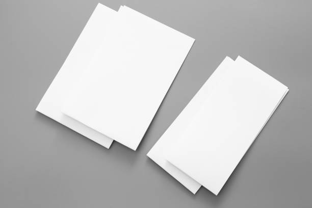 istock Blank portrait A4. brochure magazine isolated on gray, changeable background / white paper business card isolated on gray 996603544