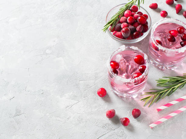 Cranberries cocktails with ice, berries and rosemary