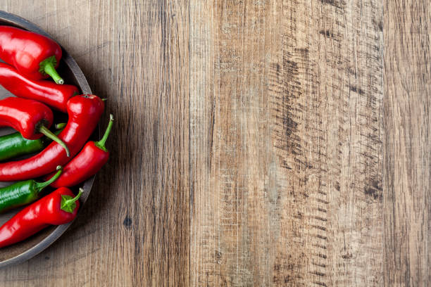 istock Red and green chilli pepper in a dish on wooden table with copy space 996622076