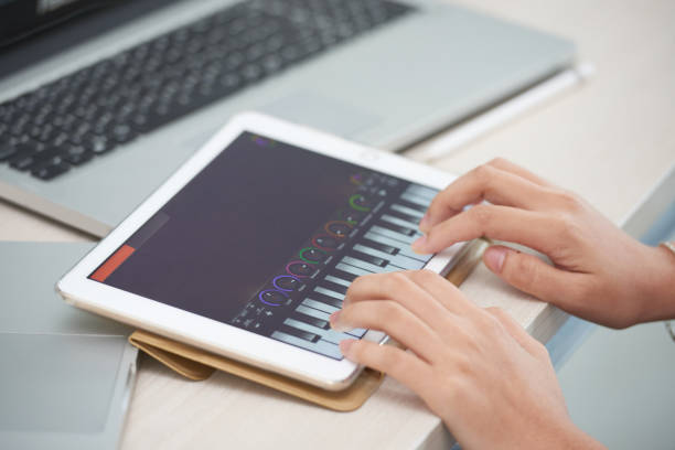 istock Female hands playing piano app on tablet 996622304
