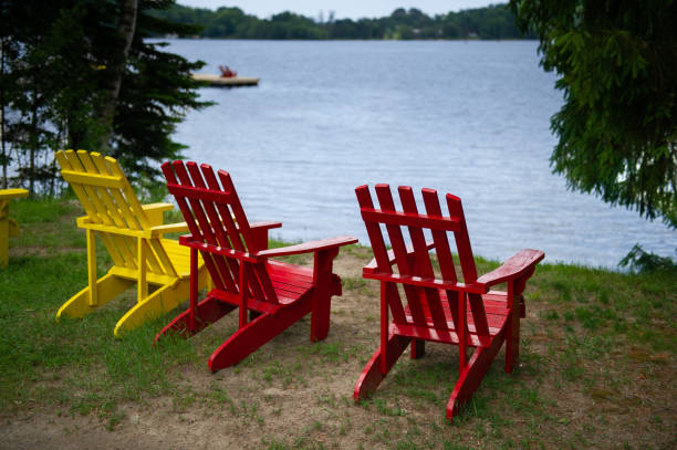 istock Muskoka chairs facing a calm lake 996636152