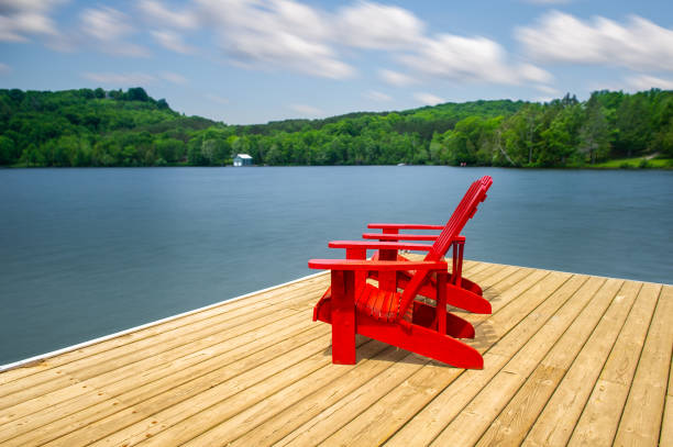 istock Red Muskoka chairs on a wooden dock 996636166