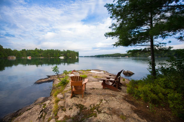 istock Muskoka chairs facing a calm lake 996636438