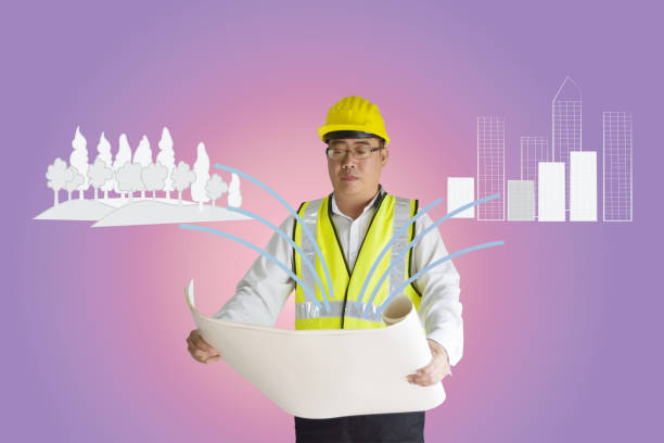 istock Asian construction engineer holding paper.Forest and building are drawn doodle lines.Concept of environmental balance and expansion of the city. 996640704