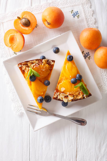 istock Apricot cheesecake with blueberry close-up on a plate. vertical top view 996659650