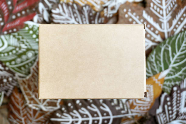 istock Craft paper box on a background of dry patterned leaves. Empty space for your design. 996660128