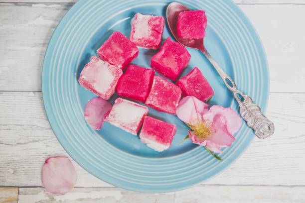 istock rose lokum and rose petals on a blue plate 996666358