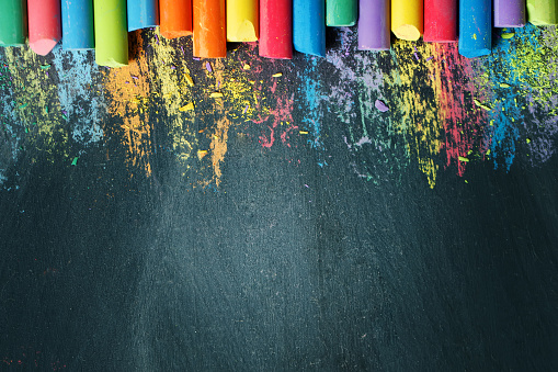 Colorful crayons on the blackboard, drawing. Back to school background. Selective focus. Background with copy space.