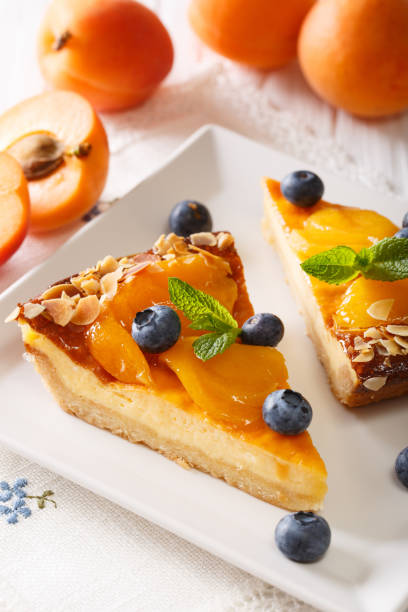 istock Cheesecake with apricots, blueberries, mint and almonds close-up on a plate. vertical 996669372