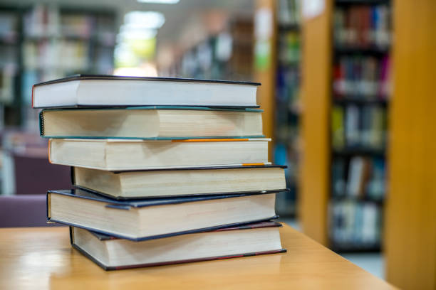 istock Book stack in the library room and blurred bookshelf for business and education background, back to school concept 996672204