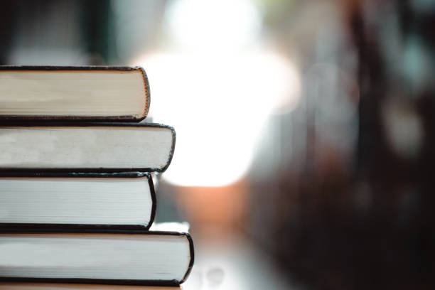 istock Book stack in the library room and blurred bookshelf for business and education background, back to school concept 996672472