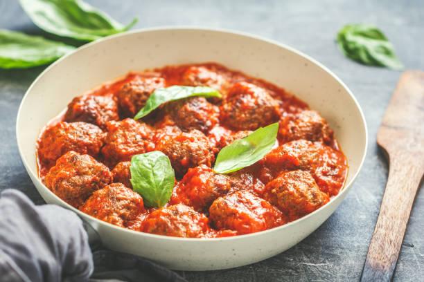 istock Meatballs with tomato sauce and basil in a white iron pan. Modern style. Dinner concept. 996679244
