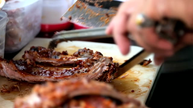 Cutting Barbecue ribs on a plate in Slow-motion pull zoom.