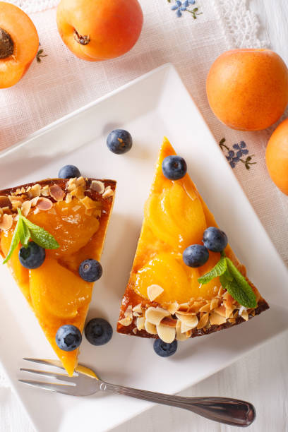 istock Apricot cake with blueberries, mint and nuts close-up on a plate. vertical top view 996686470