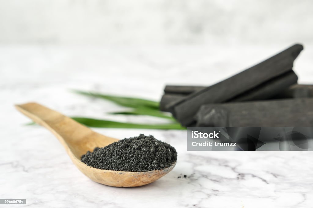 Activated charcoal powder on marble table. Coal Stock Photo