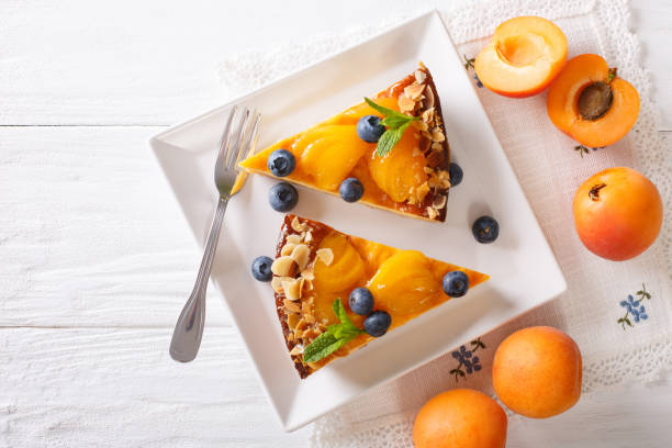 Apricot cheesecake with blueberry close-up on a plate. horizontal top view