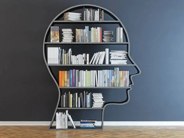 Photo of Head with a bookshelf in front of black wall