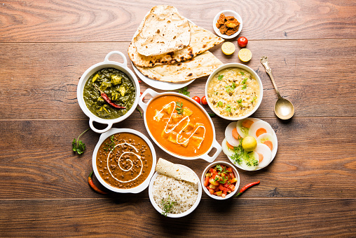 Surtido comida para almuerzo o cena, arroz, lentejas, paneer, dal makhani, naan, chutney, especias sobre fondo temperamental. enfoque selectivo photo