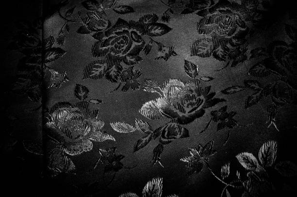 fabric, background texture. silk black fabric with a pattern of flowers. Get lost in the beautiful illustrated floral print in this black and white silk frame.