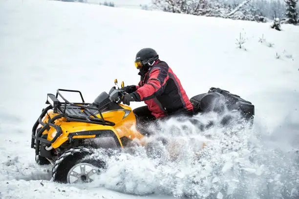Photo of Winter race on an ATV on snow in the forest.