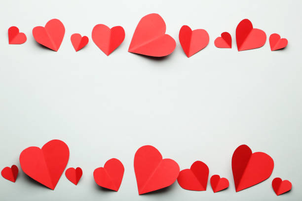 istock Red paper hearts on grey background 996717856