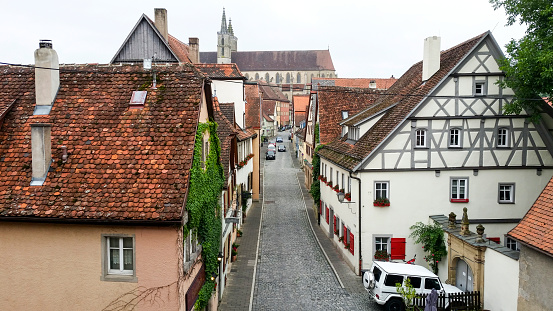 Rothenburg ob der Tauber, Germany, June 12 - 2018: Looking down the street with medieval half-timbered houses and the St. James Church or St. Jakobskirche at the end. Rothenburg is part of the Romantic Road, a scenic route through Germany.